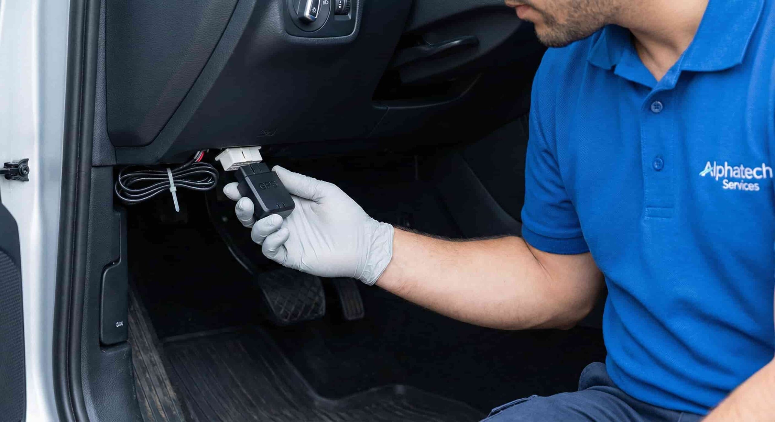 Alphatech technician installing OBD GPS tracker without wire cutting